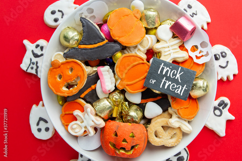 Halloween Jack o Lantern candy bowl with candy and halloween cookies Trick or Treat on red background