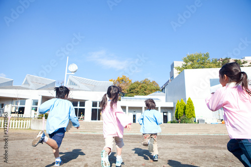 Foto 園庭を走る幼稚園児の後姿