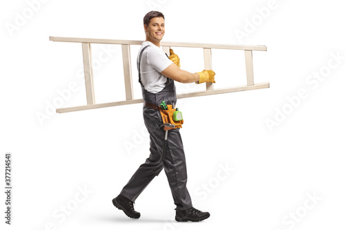 Full length shot of a repairman walking and carrying a white ladder