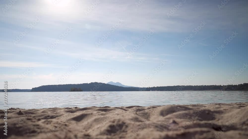 Man in fitness clothing running along sandy beach. Sportsman in leggings and yellow jersey jogging at lake. Slow motion Man in fitness clothing running along sandy beach. Sportsman in leggings and yellow jersey jogging at lake. Slow motion