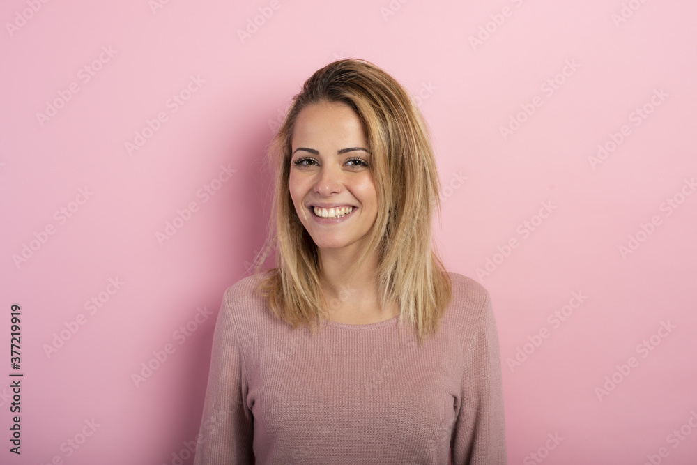 Happy and positive blonde girl against a pink background Happy and positive blonde girl against a pink background