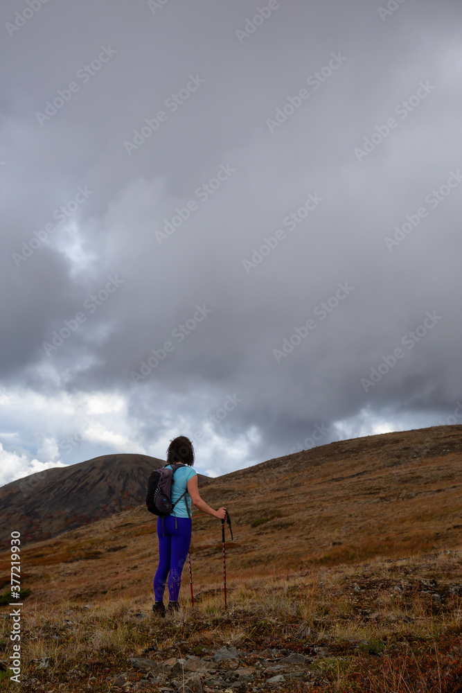 Adventurous Girl Hiking up the Nares Mountain during a cloudy and sunny evening. Taken at Carcross, near Whitehorse, Yukon, Canada. Adventurous Girl Hiking up the Nares Mountain during a cloudy and sunny evening. Taken at Carcross, near Whitehorse, Yukon, Canada.