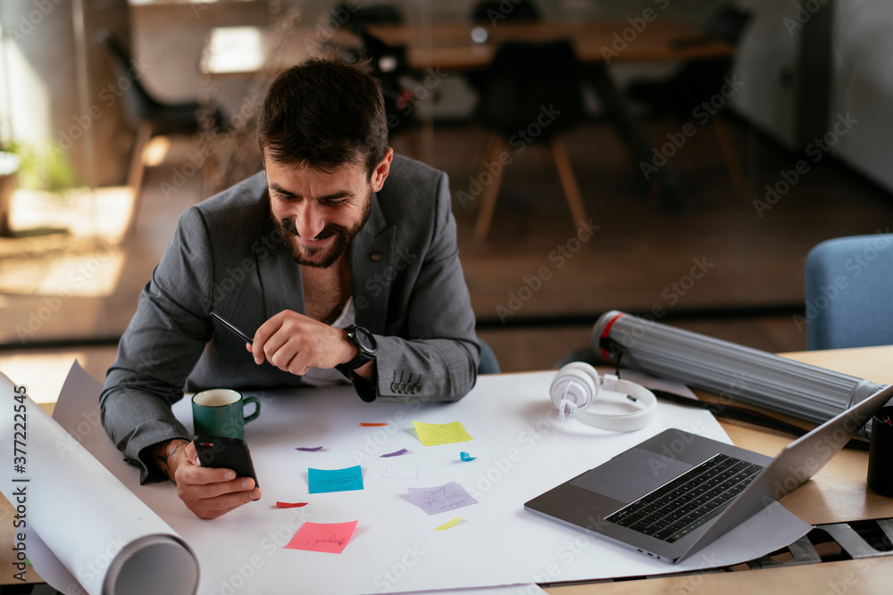 Young businessman working on projects. Handsome businessman in suit working in the office... Young businessman working on projects. Handsome businessman in suit working in the office...
