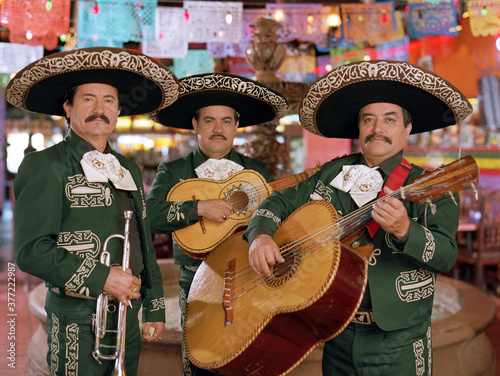 Hispanic mariachi musicians holding instruments photo
