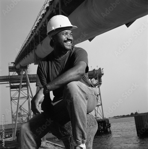Print op canvas African American male welder next to water