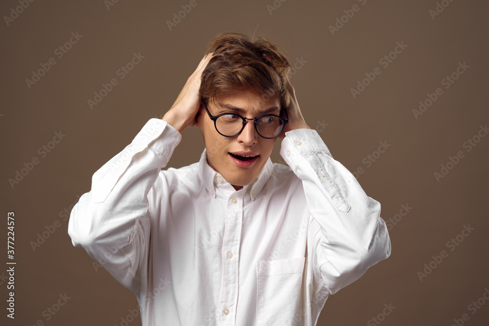 The man touches his head with his hands and looks towards the glasses The man touches his head with his hands and looks towards the glasses