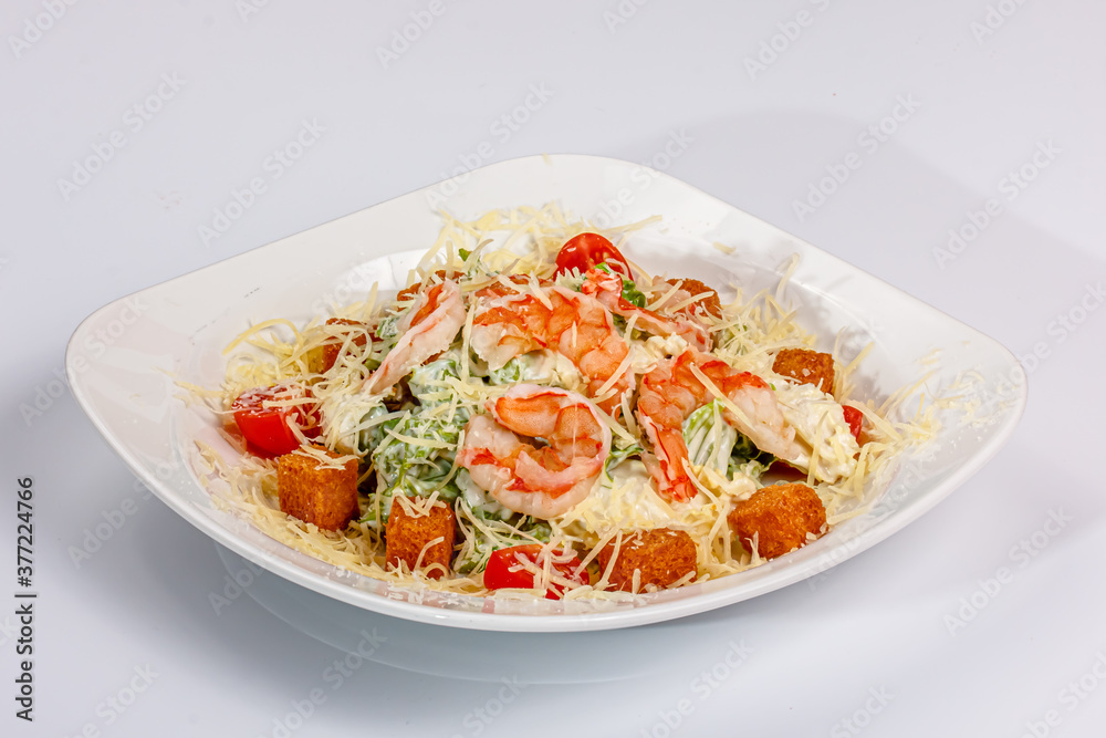 Lettuce salad with prawns and croutons is on the plate Lettuce salad with prawns and croutons is on the plate