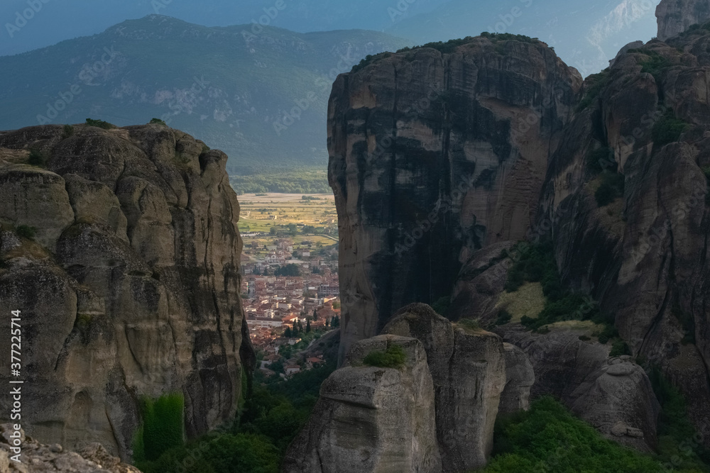 Close up of Meteora rocks in the afternoon with the city in the Valley behind