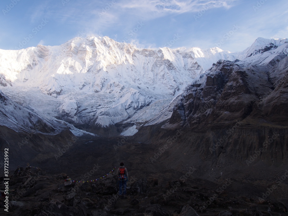 A mountain climber gaze at the snow-covered Himalayas, which rise majestically in the clear early morning air, ABC (Annapurna Base Camp) Trek, Annapurna, Nepal