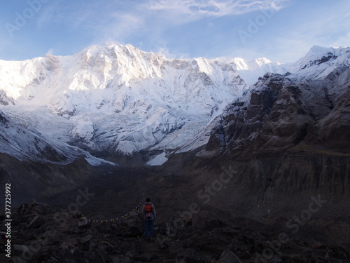 A mountain climber gaze at the snow-covered Himalayas, which rise majestically in the clear early morning air, ABC (Annapurna Base Camp) Trek, Annapurna, Nepal