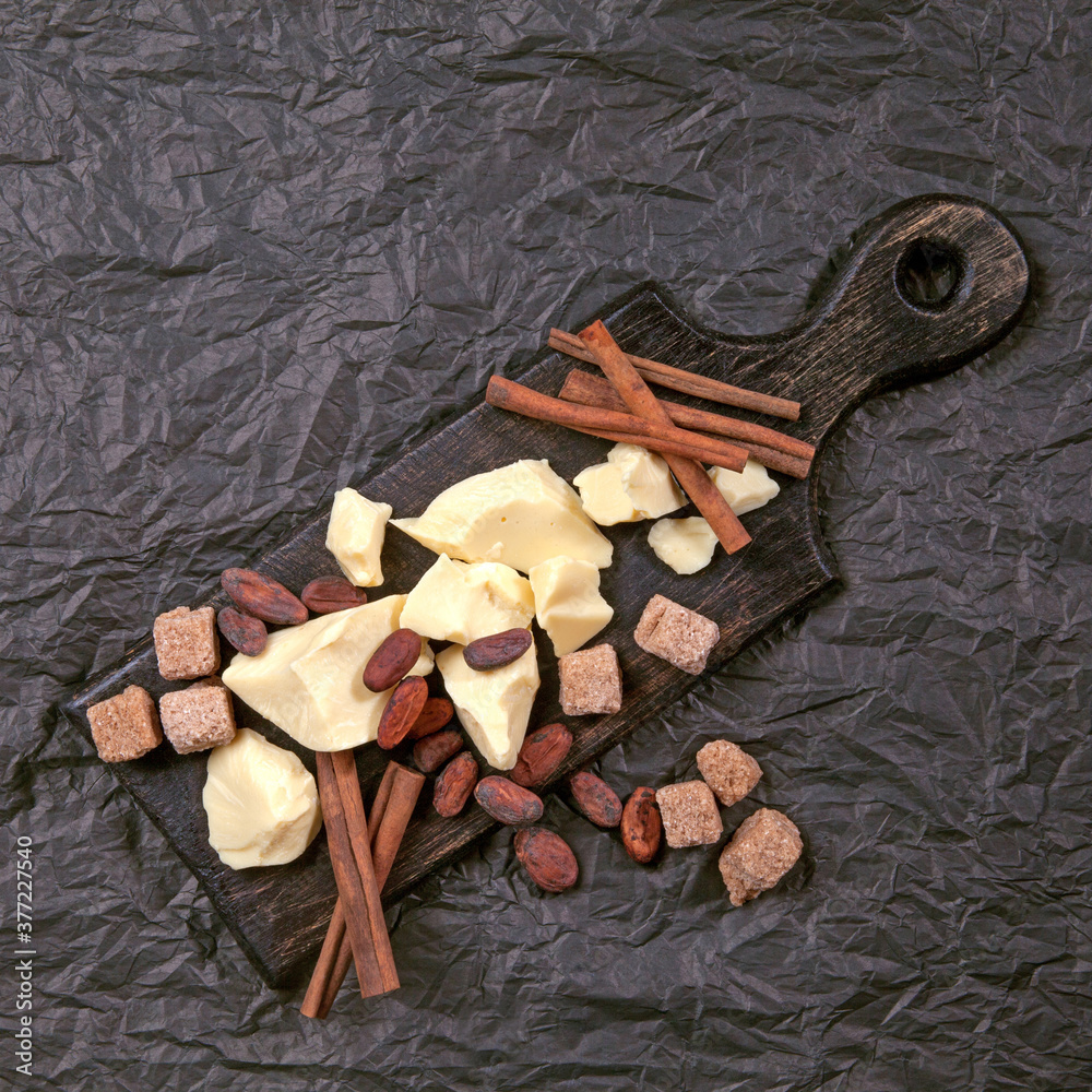 Pieces of natural cocoa butter with cinnamon, cocoa beans and cane sugar