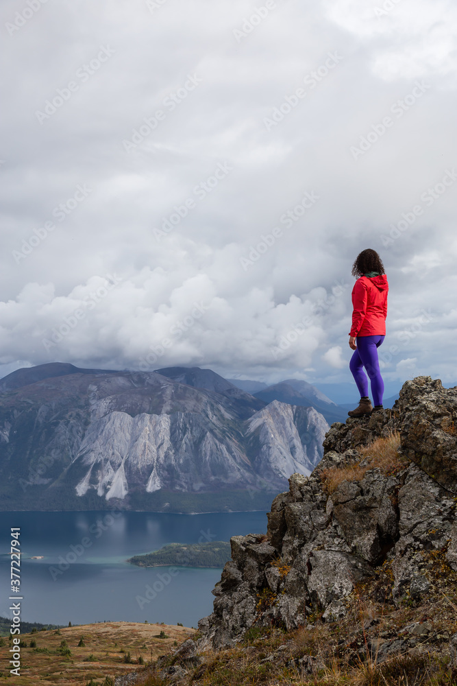 Adventurous Girl Hiking up the Nares Mountain during a cloudy and sunny evening. Taken at Carcross, near Whitehorse, Yukon, Canada. Adventurous Girl Hiking up the Nares Mountain during a cloudy and sunny evening. Taken at Carcross, near Whitehorse, Yukon, Canada.