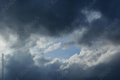 Thunder Sky. Dramatic cloudscape with blue sky in the center, surrounded by grey clouds