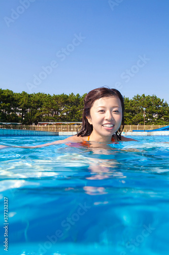 プールで遊ぶ水着姿の女性 © Paylessimages