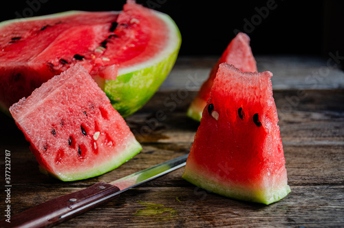 Ripe sliced watermelon on slices on a wooden table.