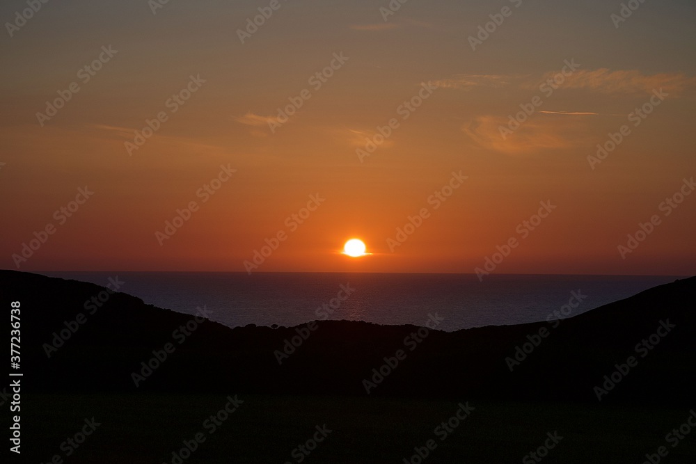 sunset over the sea between cliffs 