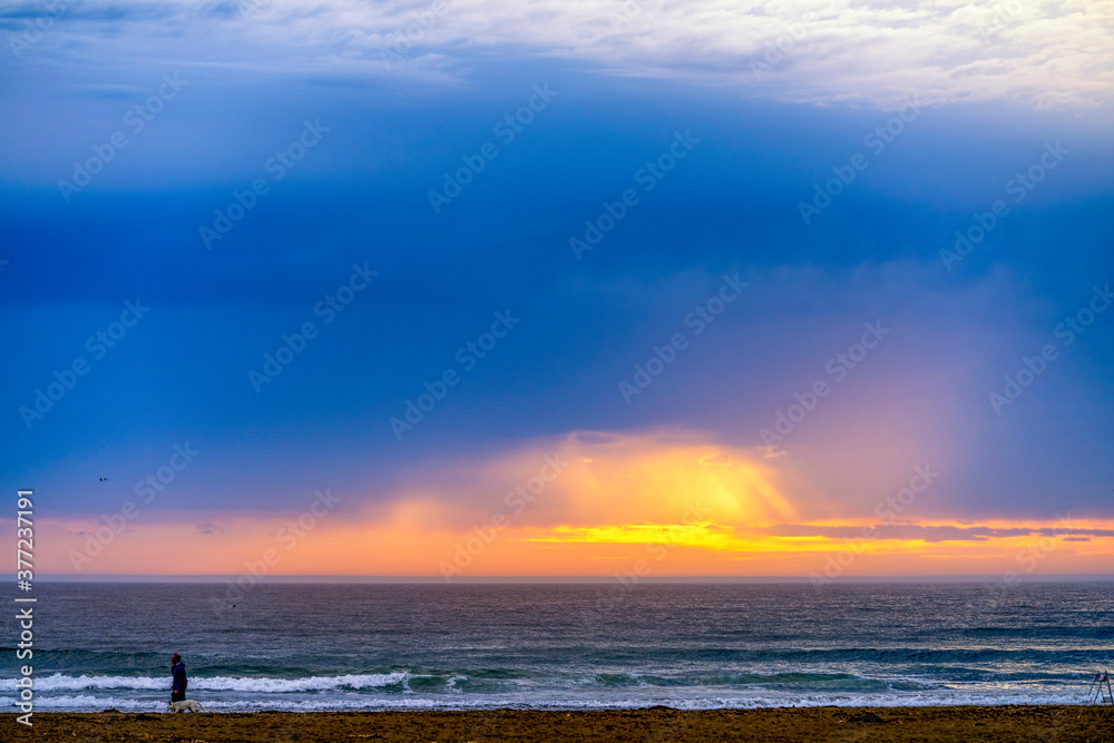 Obraz premium Sunset with sunlight through clouds, beach, ocean 