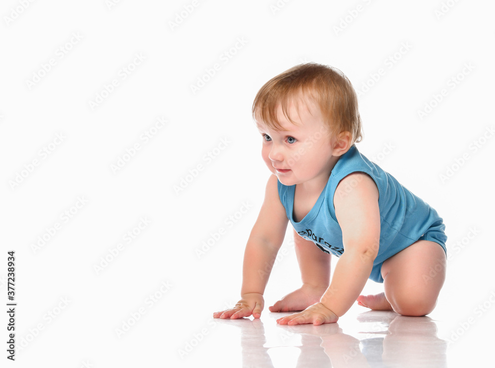 Infant child baby boy crawling and happy looking, isolated on a white background.