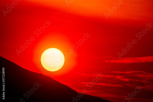 Red Sun at Sunrise over Mountainside 