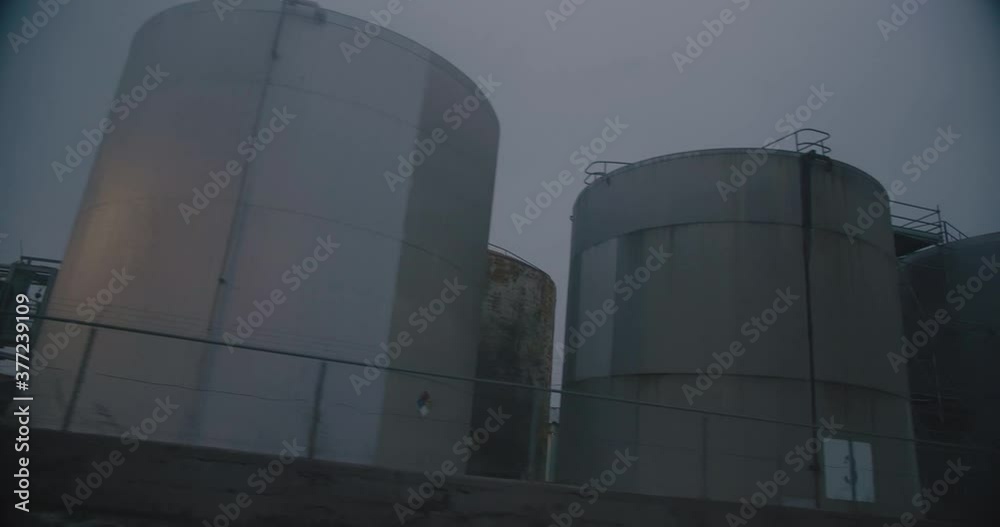 Montreal, QC, Canada - November 15 , 2017: Worm eye view of Oil refineries storage tanks, filmed while driving near Montreal East Refinery. Montreal, QC, Canada - November 15 , 2017: Worm eye view of Oil refineries storage tanks, filmed while driving near Montreal East Refinery.