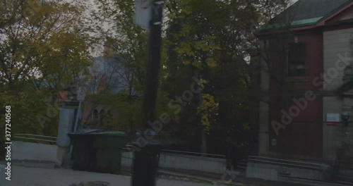 Montreal, QC, Canada - April 15 , 2017: Driving on Pine Avenue with a view of Lady Meredith House and street trees on the side of the road.