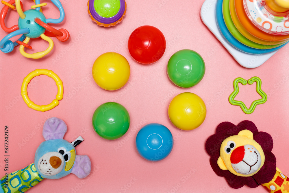 Children's toys on a pink background, copy space in the center for creative design. Flat lay.