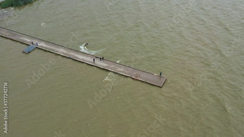 AERIAL: Surfer Swims Toward Stone Bridge and Stops at Very Last Second