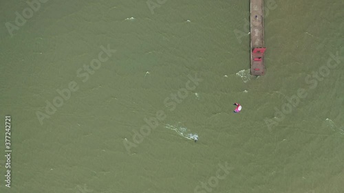 AERIAL: Top View of Surfer Riding Green Wave of Baltic Sea