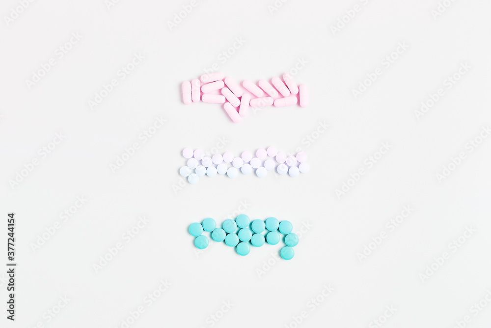 minimal concept. composition of pills and capsules of pastel gradient color on a white background. vitamin skincare, flat lay, top view