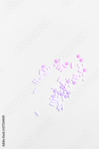 simple medicine concept. pills and capsules of pink color on a white background. flat lay