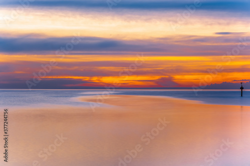 Long exposure minimalist sunset over sea with text space. Beautiful vivid golden orange colors