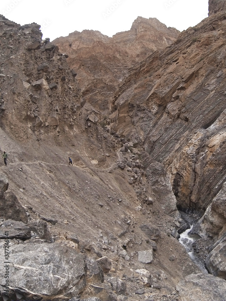 Nomads walking on a steep path in Ladakh in the Indian Himalayas. 