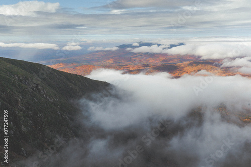 Fall mountainside surrounded by clouds