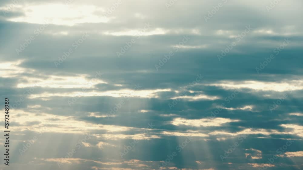 Sun Rays Shining Through Cloudy Sky With Fluffy Clouds. Sky Natural Background. Weather Forecast Concept Sun Rays Shining Through Cloudy Sky With Fluffy Clouds. Sky Natural Background. Weather Forecast Concept