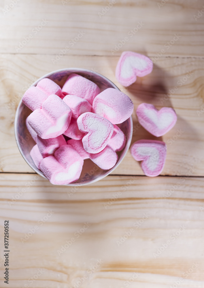 Marshmallows heart on wood background in vintage tone