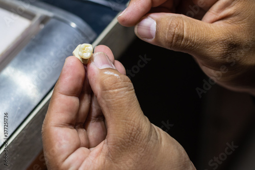 Holding a ceramic tooth after being in the oven