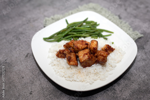 Homemade  Pork with rice on a white plate and green beans