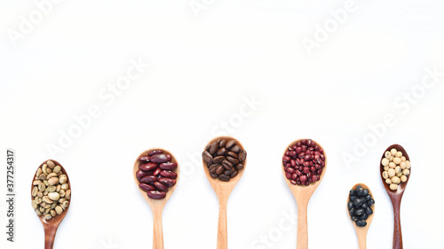Assortment of beans and lentils on spoon isolated on white background