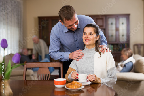 Portrait of happy couple drinking tea together at parents home