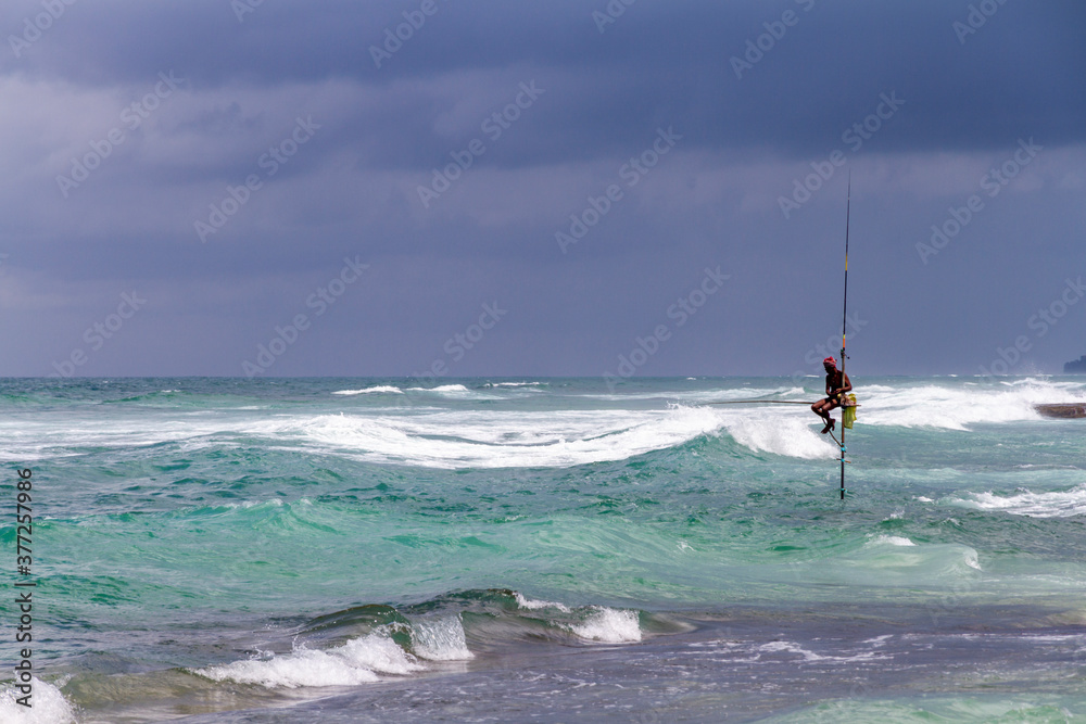 Distant traditional pole or stilt fishermen on a stormy day in Koggala, on the south west coast of Sri Lanka. Distant traditional pole or stilt fishermen on a stormy day in Koggala, on the south west coast of Sri Lanka.