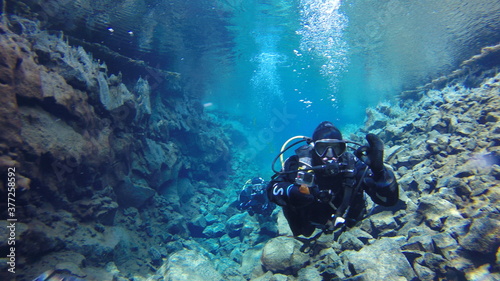 diver in drysuit swimming in icelandic glacial water