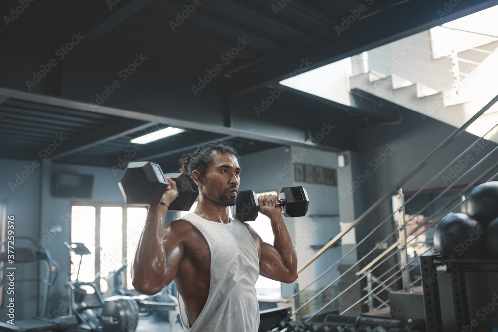 Man Workout With Dumbbells At Gym. Asian Sportsman On Intense Training At Fitness Center. Sexy Guy Using Heavy Sport Equipment For Strong, Healthy, Muscular Body. Man Workout With Dumbbells At Gym. Asian Sportsman On Intense Training At Fitness Center. Sexy Guy Using Heavy Sport Equipment For Strong, Healthy, Muscular Body.