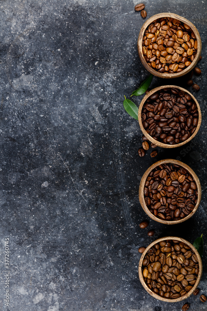Flat lay of Four different varieties of coffee beans on dark marble background Flat lay of Four different varieties of coffee beans on dark marble background