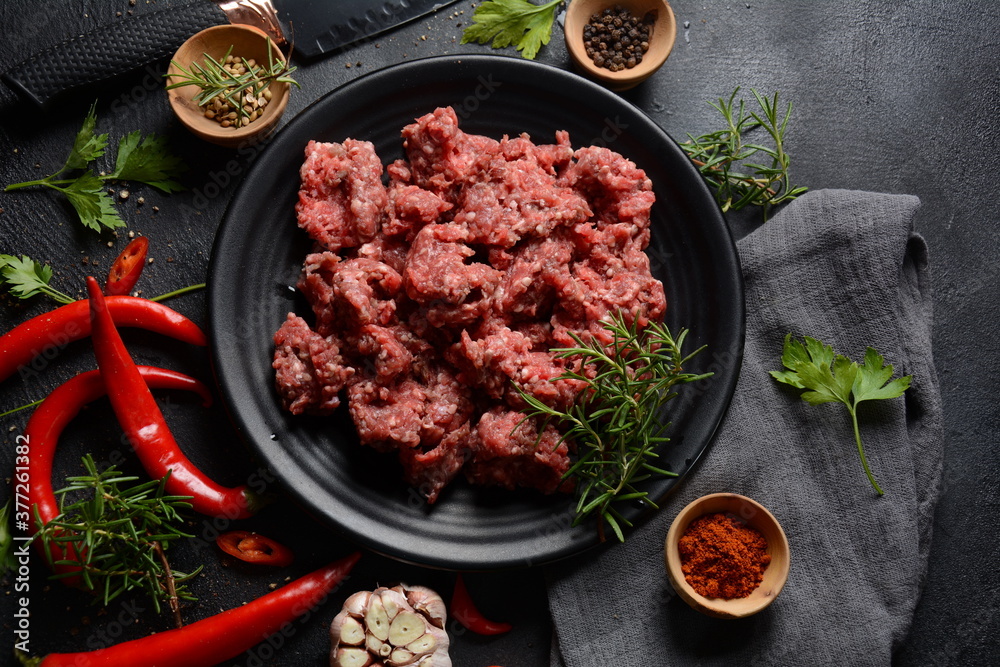 Minced beef. Ground meat with ingredients for cooking on black background Minced beef. Ground meat with ingredients for cooking on black background