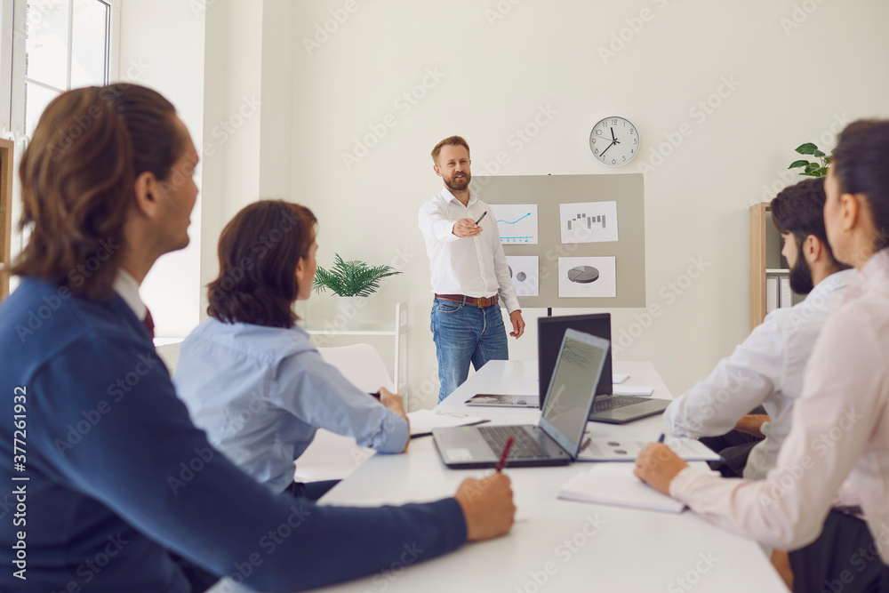 Young Marketing or Sales Department worker making presentation in a corporate meeting