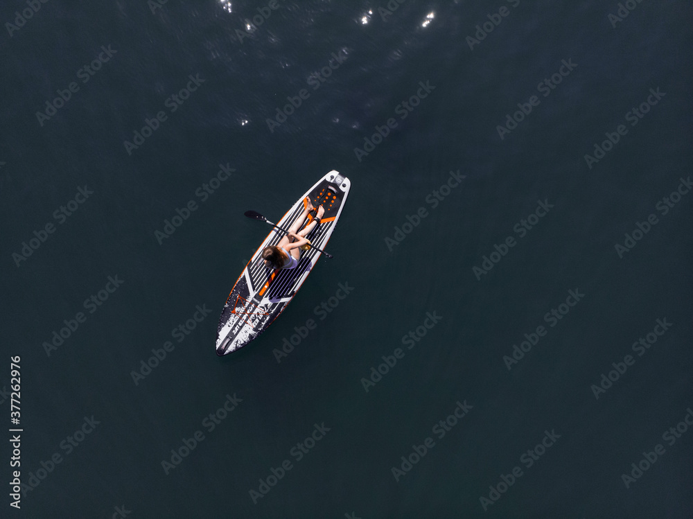 Attractive Woman on Stand Up Paddle Board, Woman paddling on sup board and enjoying turquoise transparent water. Tropical travel, wanderlust and water activity concept. Sunset and relax Attractive Woman on Stand Up Paddle Board, Woman paddling on sup board and enjoying turquoise transparent water. Tropical travel, wanderlust and water activity concept. Sunset and relax