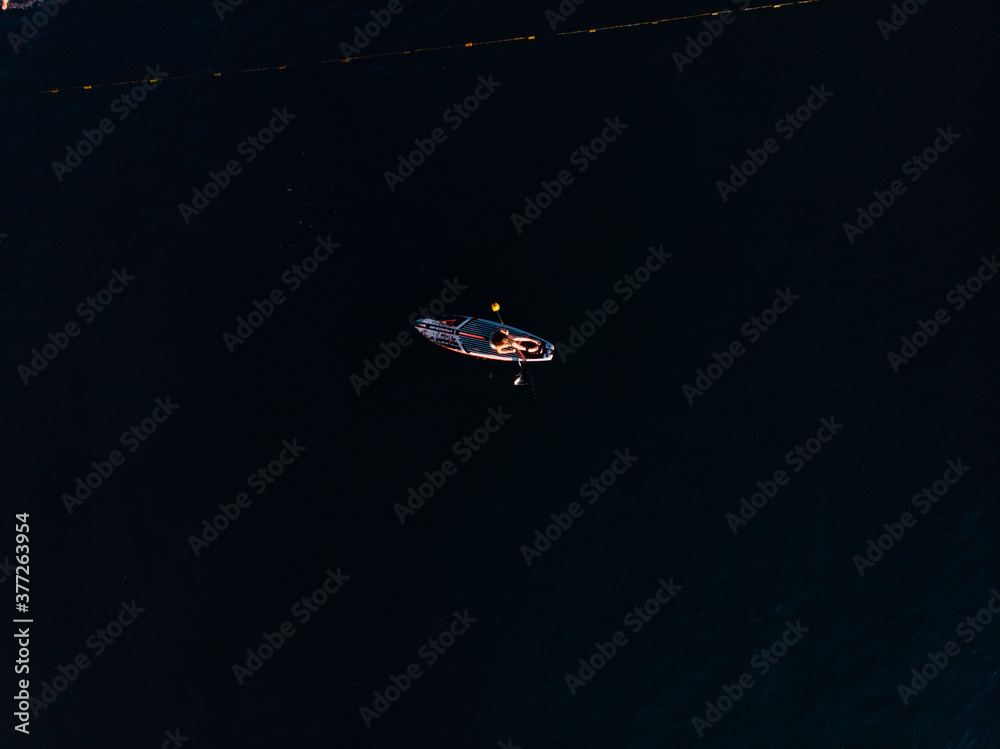 Naklejka premium Attractive Woman on Stand Up Paddle Board, Woman paddling on sup board and enjoying turquoise transparent water. Tropical travel, wanderlust and water activity concept. Sunset and relax