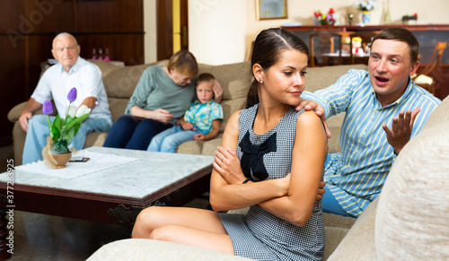 Young frustrated woman having problems in relationship with her large family