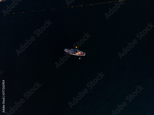 Attractive Woman on Stand Up Paddle Board, Woman paddling on sup board and enjoying turquoise transparent water. Tropical travel, wanderlust and water activity concept. Sunset and relax photo