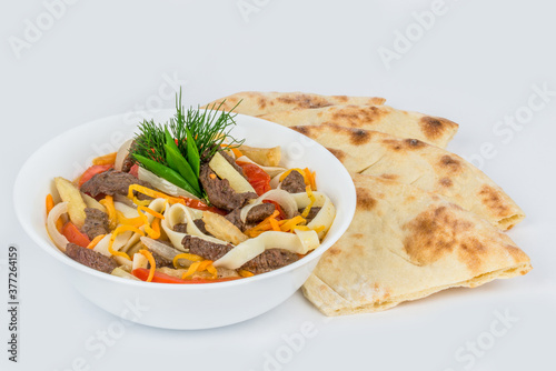 Lagman in a white, round plate with a flatbread